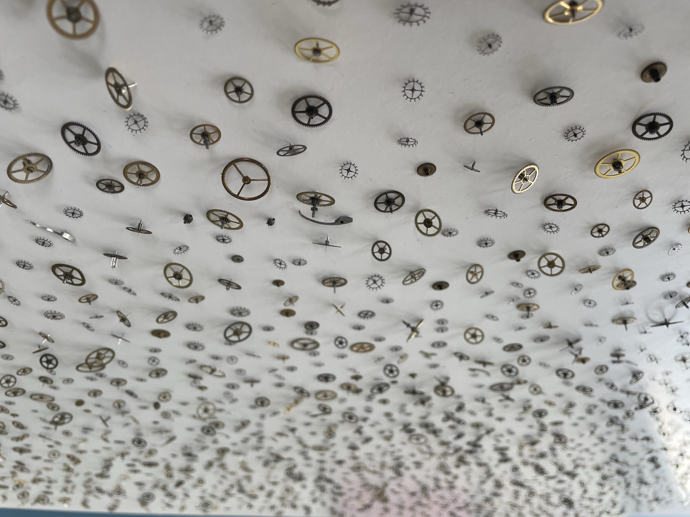 Viele kleine Zahnräder in einer räumlichen Installation